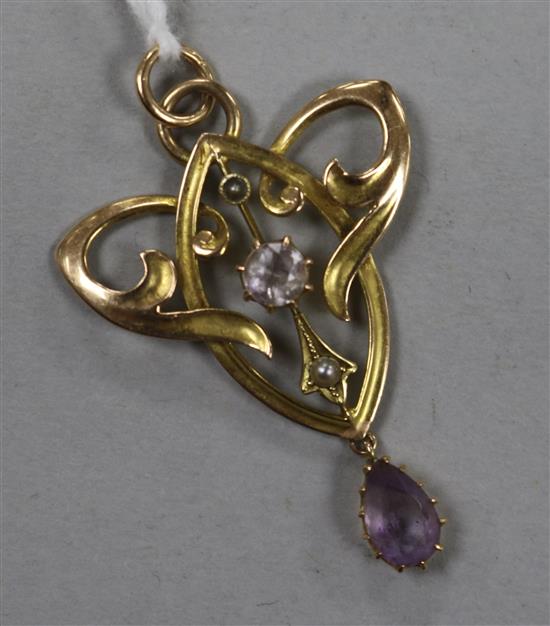 An Art Nouveau 15ct gold and gem set scrolling pendant, 37mm.